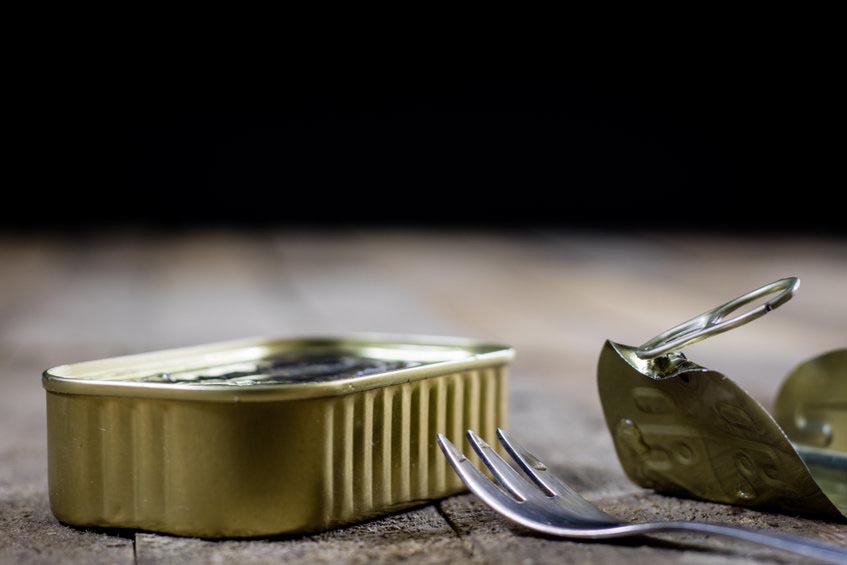 Lata de conserva del mar con un tenedor preparada para consumir