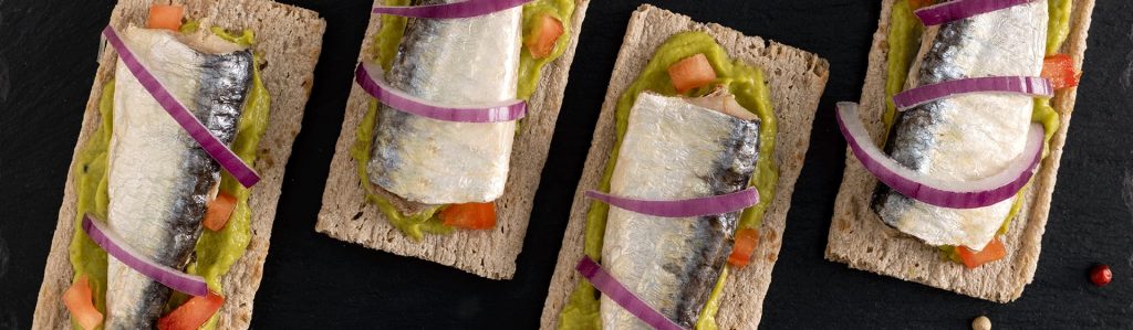 Tosta de sardina con guacamole, tomate y cebolla roja dulce