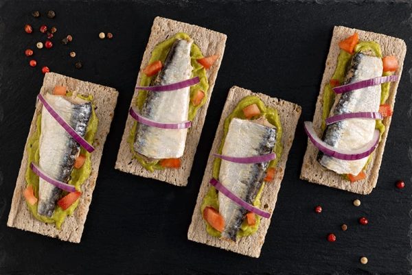 Tosta de sardina con guacamole, tomate y cebolla roja dulce