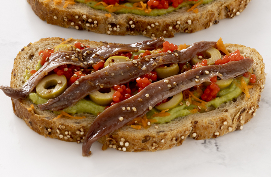 Tosta de anchoas con aguacate, aceitunas y huevas rojas